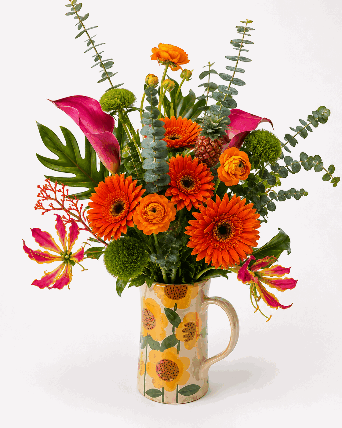 Arranjo de Gérberas e Calas Grande - Gérberas laranja e copos-de-leite vermelhos, servidos em caneca estampada. Cor sem meio-termo.